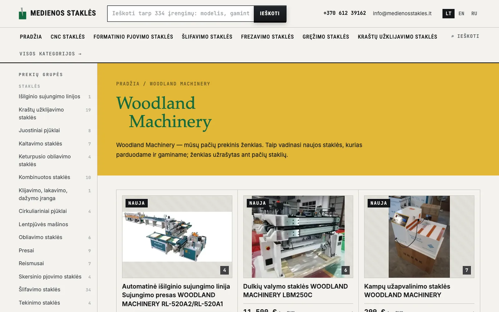 Woodland Machinery puslapis su auksine juosta ir staklių kortelėmis su kainomis be PVM
